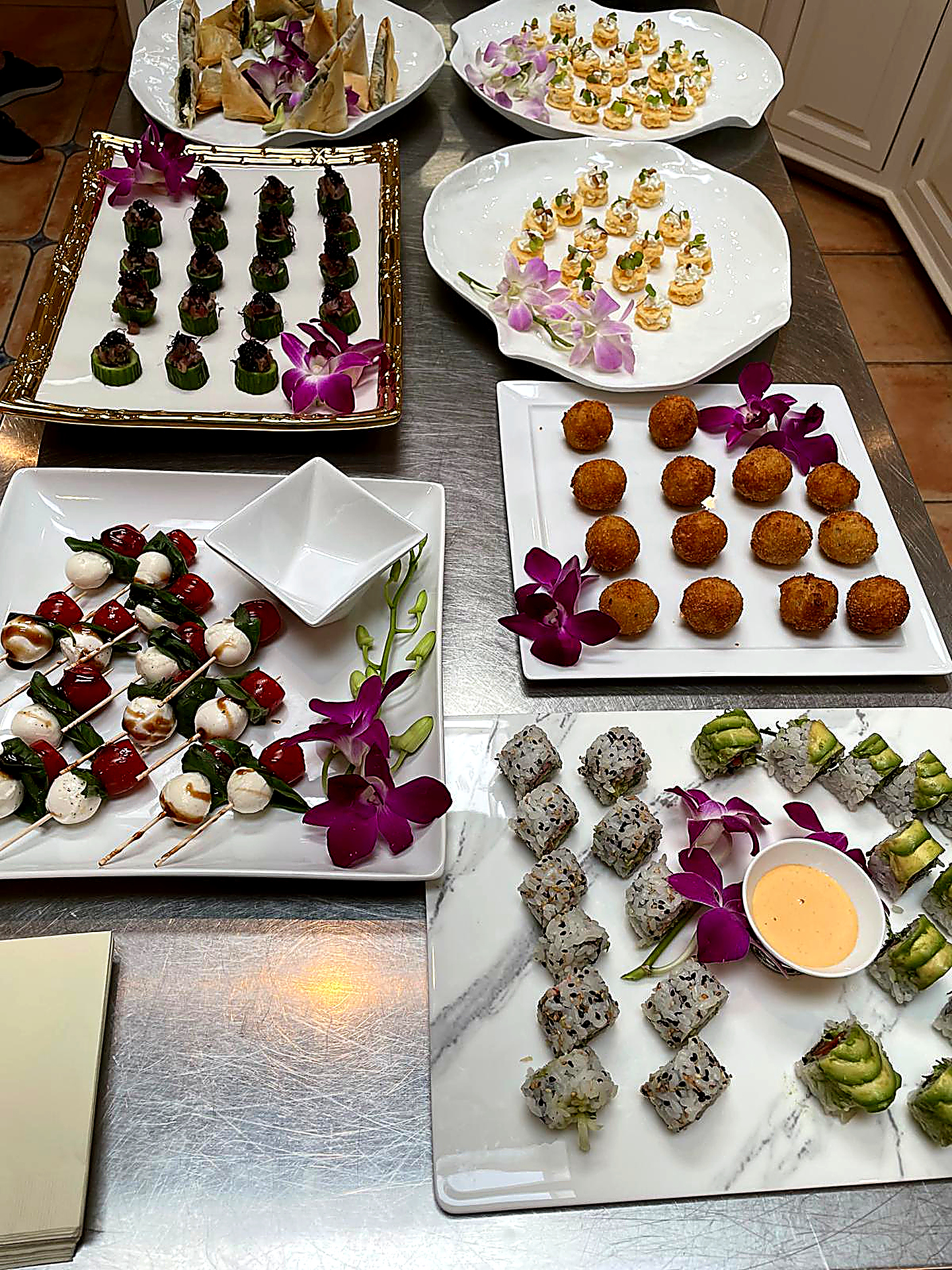Full appetizer spread of sushi, caprese, and croquettes