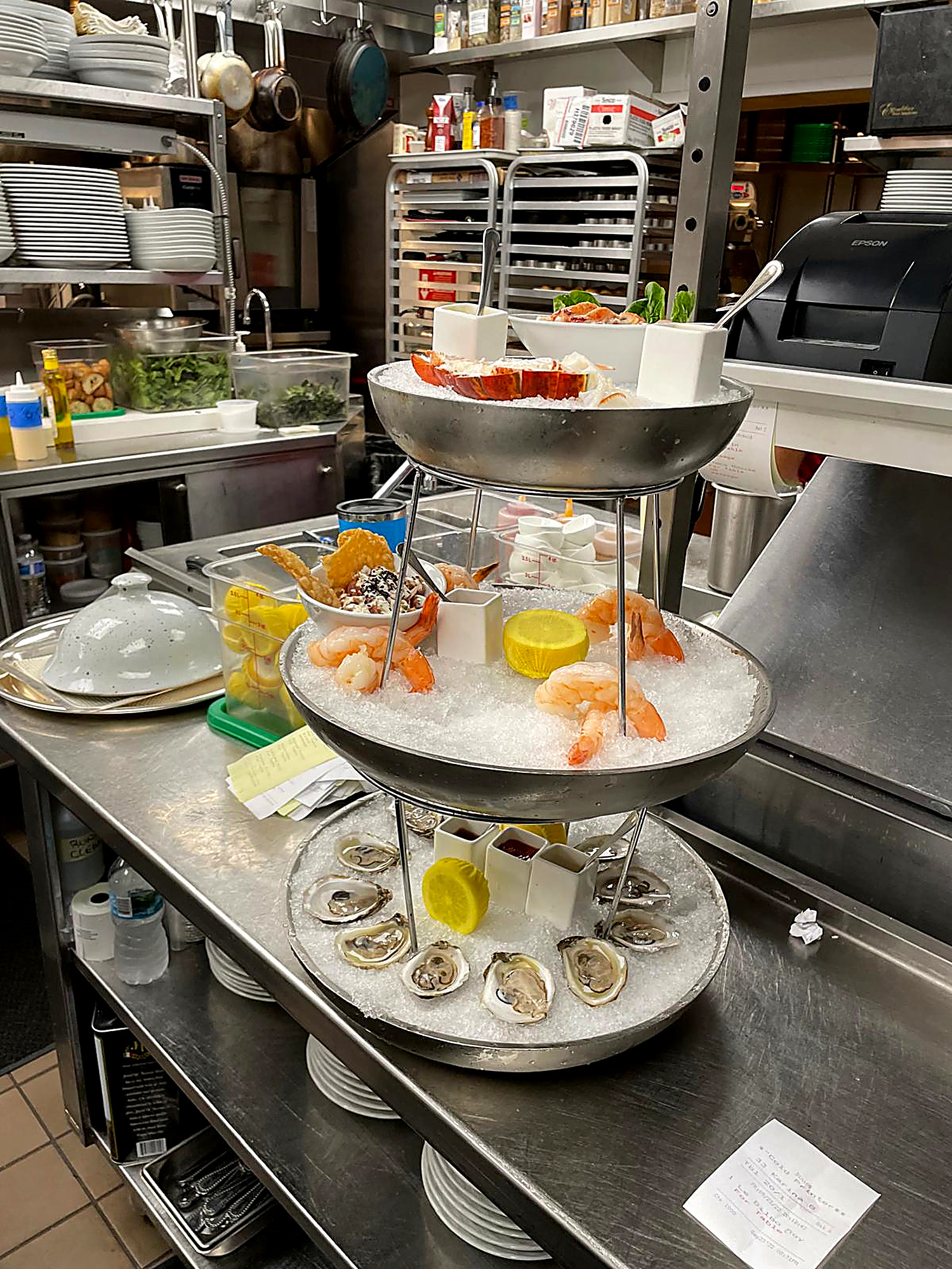 Three-tier seafood tower with oysters, shrimp, and lobster